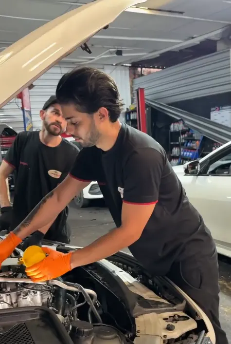 Mecânicos da Cristo Rei trabalhando no motor de um veículo em Contagem